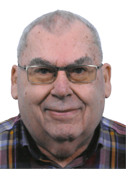 Portrait eines &auml;lteren Mannes mit Brille, kurzem grauem Haar und kariertem Hemd vor wei&szlig;em Hintergrund.