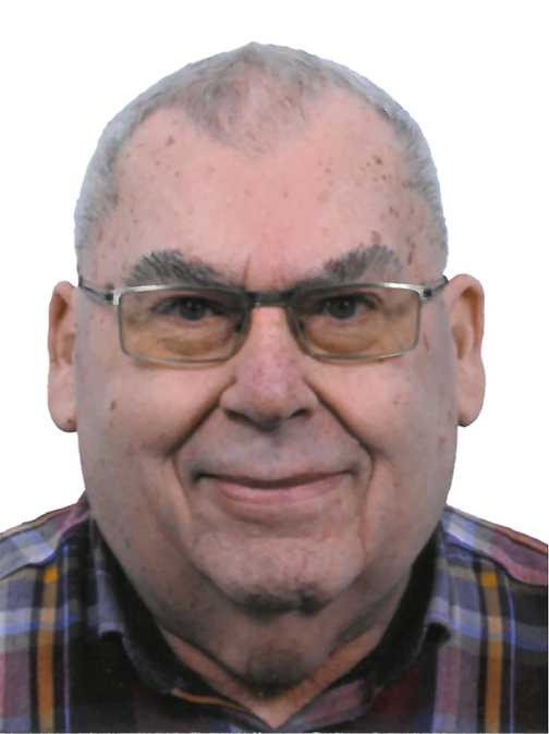 Portrait eines &auml;lteren Mannes mit Brille, kurzem grauem Haar und kariertem Hemd vor wei&szlig;em Hintergrund.