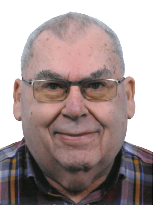 Portrait eines &auml;lteren Mannes mit Brille, kurzem grauem Haar und kariertem Hemd vor wei&szlig;em Hintergrund.