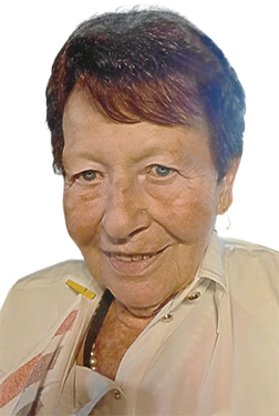 Portr&auml;t einer &auml;lteren Frau mit kurzem, dunklem Haar, l&auml;chelnd vor einem hellen Hintergrund. Sie tr&auml;gt eine helle Bluse und Ohrringe.