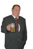 Mann in traditioneller Kleidung hält ein großes Glas Bier, lächelnd und stehend mit einer Hand in der Hosentasche.