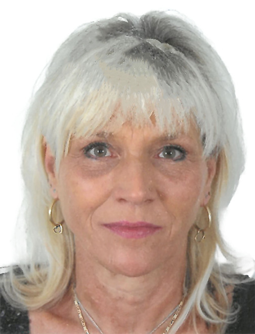 Portrait einer Frau mit blonden, schulterlangen Haaren, die ein schwarzes Oberteil tr&auml;gt und Ohrringe tr&auml;gt.