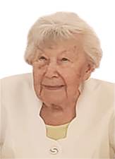 &Auml;ltere Frau mit blonden, schulterlangen Haaren, tr&auml;gt eine wei&szlig;e Jacke und schaut leicht l&auml;chelnd.