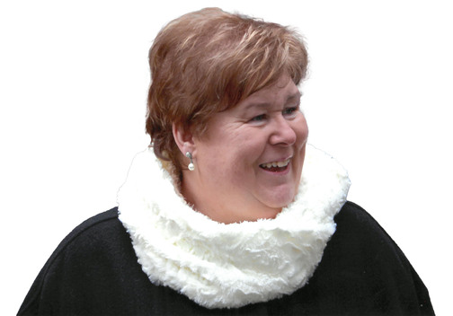 L&auml;chelnde Frau mit kurzen, braunen Haaren und einem wei&szlig;en Loop-Schal vor wei&szlig;em Hintergrund.