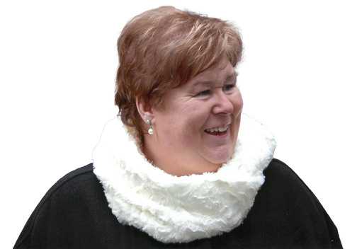 L&auml;chelnde Frau mit kurzen, braunen Haaren und einem wei&szlig;en Loop-Schal vor wei&szlig;em Hintergrund.