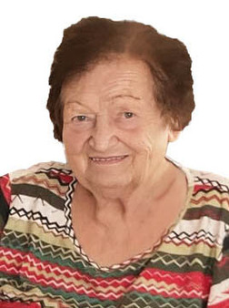 Portr&auml;t einer &auml;lteren Frau mit freundlichem L&auml;cheln, in einem bunten, gemusterten Oberteil.