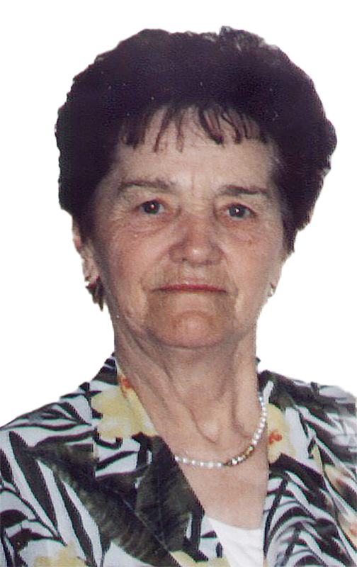 Portr&auml;t einer &auml;lteren Frau mit dunklem Haar, Bluse mit Blumenmuster und einer Perlenkette um den Hals.