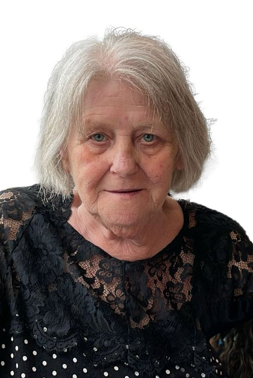 Portr&auml;t einer &auml;lteren Frau mit grauen Haaren und blauer Bluse, die freundlich in die Kamera schaut.