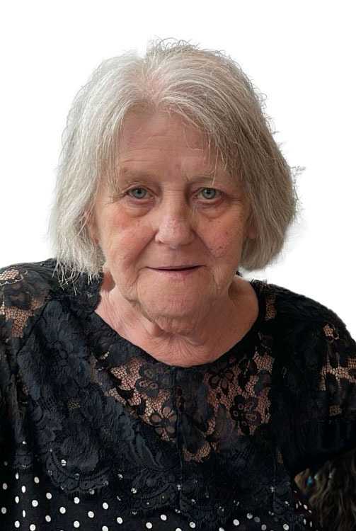Portr&auml;t einer &auml;lteren Frau mit grauen Haaren und blauer Bluse, die freundlich in die Kamera schaut.