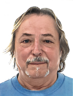 Portr&auml;t eines Mannes mit schulterlangen Haaren und Schnurrbart, der ein blaues Oberteil tr&auml;gt. Hintergrund ist wei&szlig;.