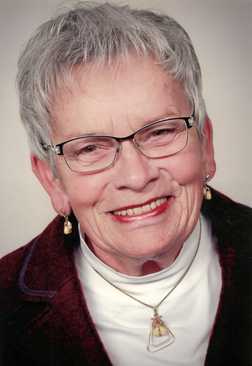 Portrait einer &auml;lteren Frau mit grauem Haar, Brille, Schmuck und Smiling auf neutralem Hintergrund.
