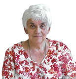 &Auml;ltere Frau mit kurzen, wei&szlig;en Haaren und bl&uuml;hendem, rot-wei&szlig;en Oberteil, freundlich in die Kamera blickend.