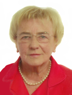 Portr&auml;t einer &auml;lteren Frau mit kurzen blonden Haaren, Brille und einem roten Blazer, vor wei&szlig;em Hintergrund.