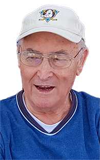 &Auml;lterer Mann mit Brille und heller Baseballm&uuml;tze, tr&auml;gt einen blauen Pullover, l&auml;chelt freundlich in die Kamera.
