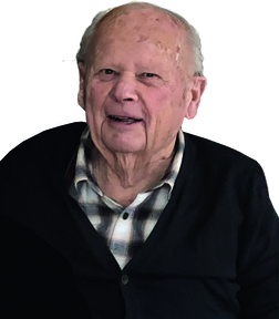 Portr&auml;t eines &auml;lteren Mannes mit freundlichem Gesicht, trug einen schwarzen Pullover &uuml;ber einem karierten Hemd.