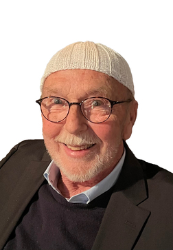 L&auml;chelnder &auml;lterer Mann mit Brille, Tr&auml;gerschl&auml;ger auf dem Kopf, schwarzem Blazer und dunklem Pullover.