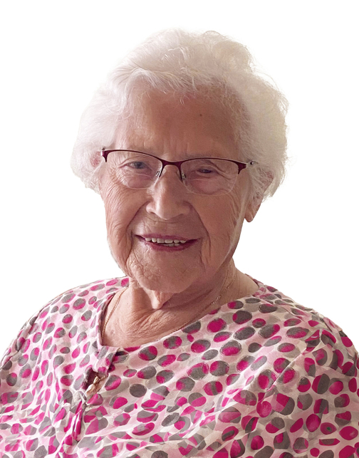 Portr&auml;t einer &auml;lteren Frau mit Brille und lockigem, wei&szlig;em Haar, die ein gepunktetes Oberteil tr&auml;gt und l&auml;chelt.