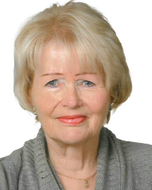 Portrait einer Frau mit blonden Haaren, die in einem grauen Oberteil vor einem wei&szlig;en Hintergrund l&auml;chelt.