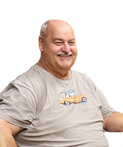 L&auml;chelnder Mann mit Glatze tr&auml;gt ein graues T-Shirt mit einer bunten Fahrzeugmotivation.