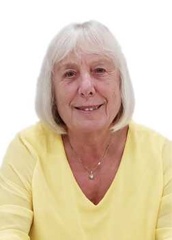Portrait einer l&auml;chelnden &auml;lteren Frau mit blonden Haaren, die ein gelbes Oberteil tr&auml;gt, vor wei&szlig;em Hintergrund.