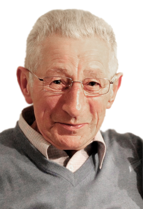 Portr&auml;t eines &auml;lteren Mannes mit Brille, grauem Haar und Pullover, der l&auml;chelnd in die Kamera schaut.