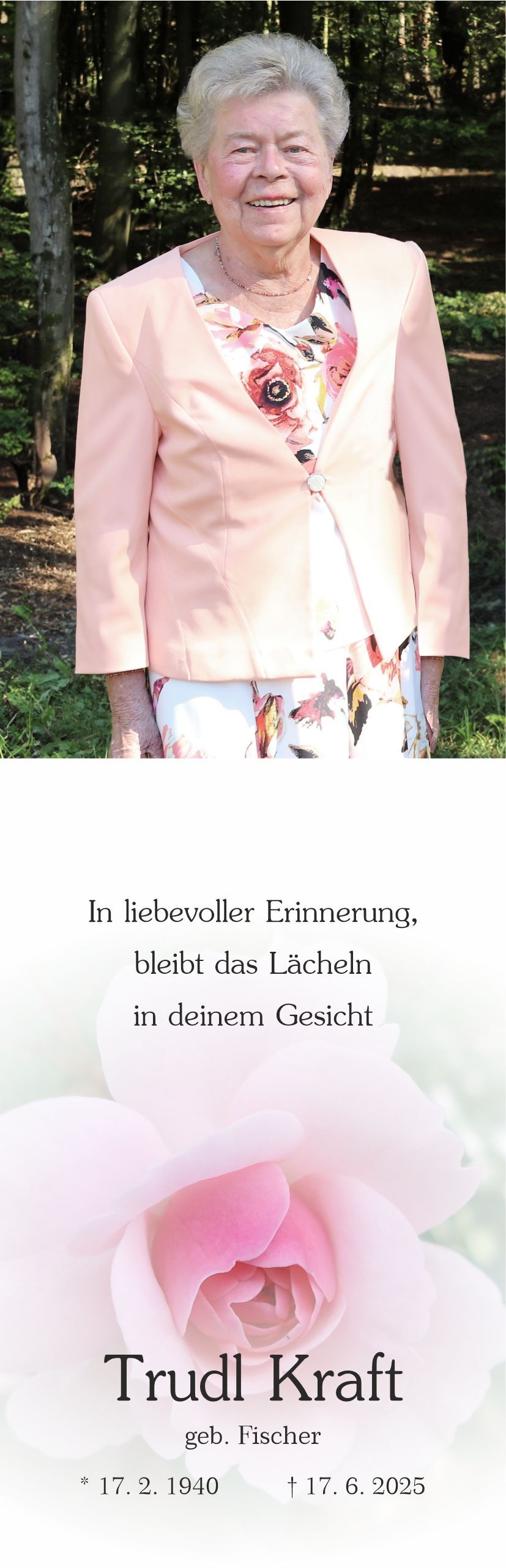 Portrait einer &auml;lteren Frau mit kurzer grauer Frisur, l&auml;chelnd vor einem Waldhintergrund, in blasser Jacke und floralem Kleid.