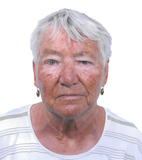 Porträt einer älteren Frau mit kurzen, grauen Haaren, die ein gestreiftes Shirt und Ohrhänger trägt.