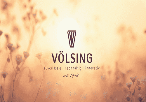 Logo von V&ouml;lsing vor einem verschwommenen, bl&uuml;henden Hintergrund mit dem Slogan: &bdquo;zuverl&auml;ssig, nachhaltig, innovativ seit 1948&ldquo;.