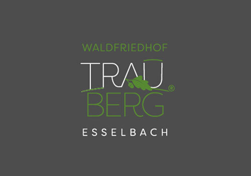 Logo des Waldfriedhofs TrauBerg in Esselbach, bestehend aus grünem Schriftzug und stilisiertem Blatt.