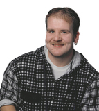 Portrait eines l&auml;chelnden Mannes mit kurzen Haaren, einem karierten Hemd und einem Ohringe. Hintergrund ist wei&szlig;.