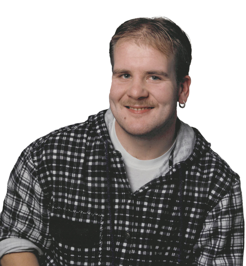 Portrait eines l&auml;chelnden Mannes mit kurzen Haaren, einem karierten Hemd und einem Ohringe. Hintergrund ist wei&szlig;.