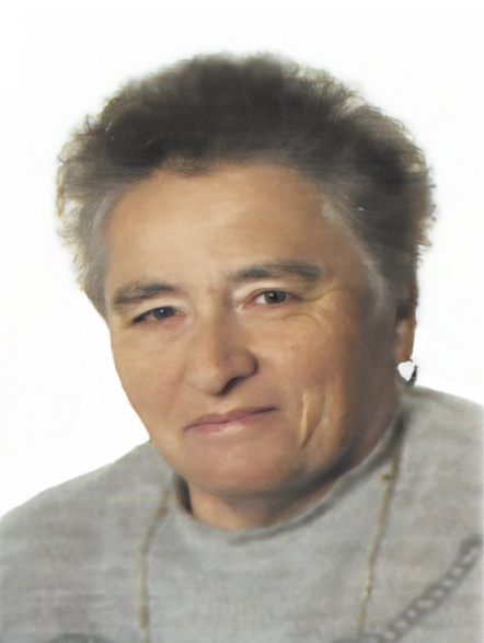 Portr&auml;t einer &auml;lteren Frau mit kurzem grauem Haar, die in die Kamera schaut und eine neutrale Miene zeigt.