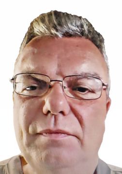 Nahaufnahme eines Mannes mit Brille und kurzem grauem Haar vor einem wei&szlig;en Hintergrund.