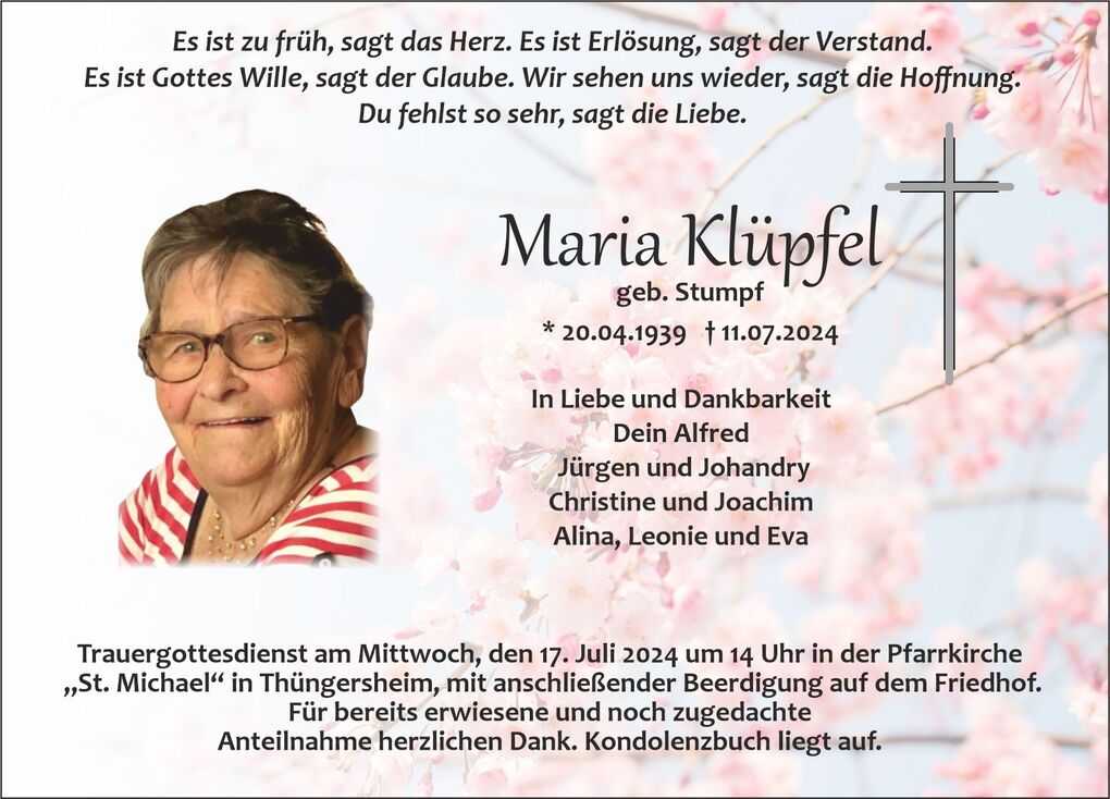 Portr&auml;t einer l&auml;chelnden &auml;lteren Frau mit Brille, umgeben von einer bl&uuml;henden Kirschbl&uuml;ten-Umrahmung.