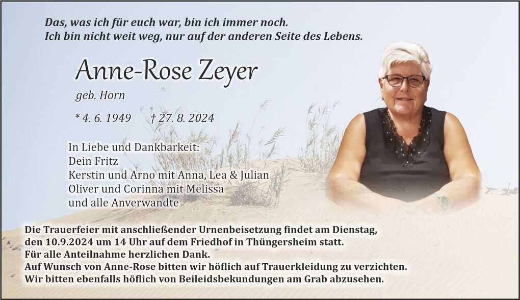 Trauerkarte mit Bild einer Frau, Namen und Lebensdaten sowie Hinweisen zur Trauerfeier auf sandigem Hintergrund.