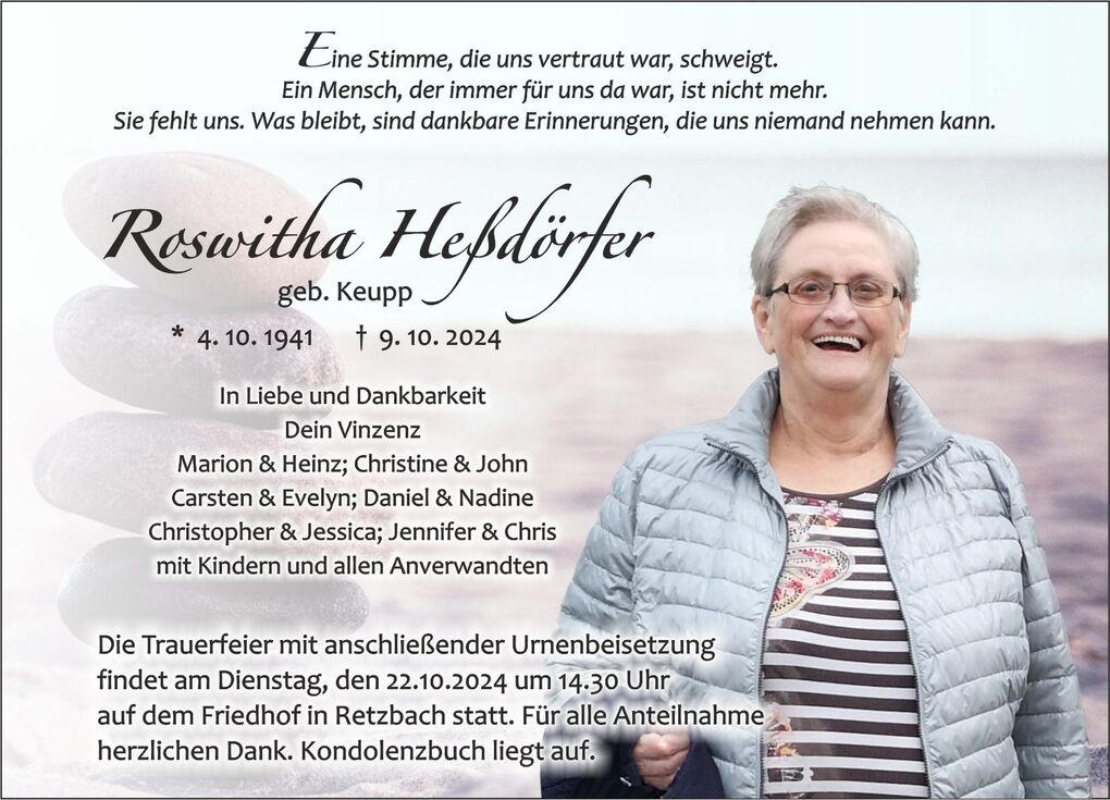 Frau mit Brille und grauer Jacke l&auml;CHELT vor einer sanften, verschwommenen Landschaft, mit einer Traueranzeige im Hintergrund.