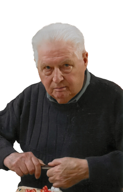 &Auml;lterer Mann mit wei&szlig;em Haar, der konzentriert mit einer Klinge an einem Objekt arbeitet, tr&auml;gt einen dunklen Pullover.