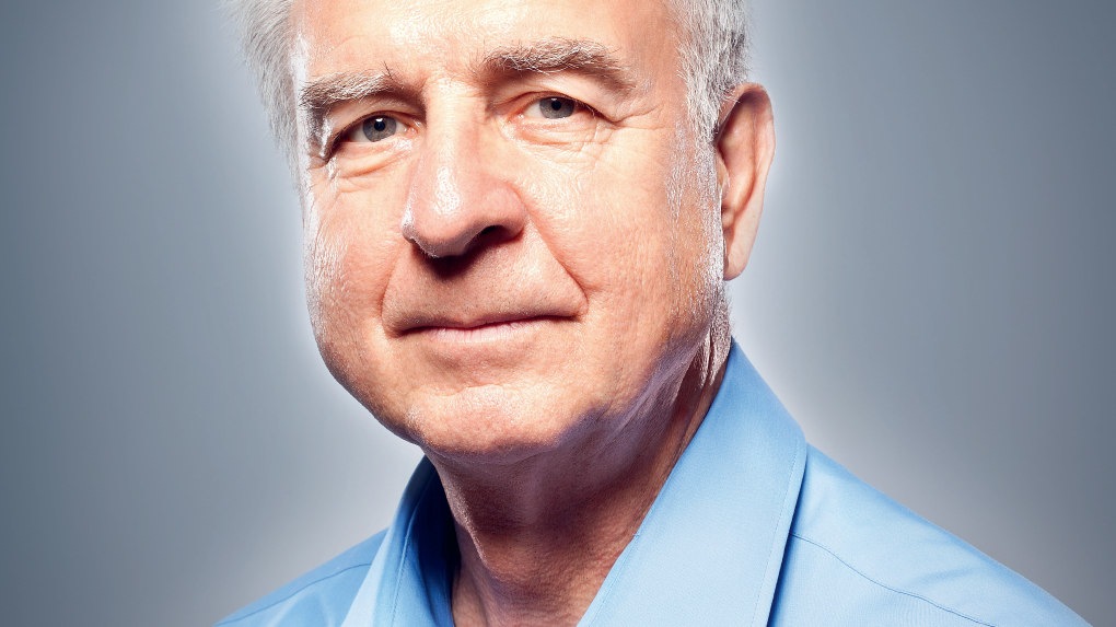 Portr&auml;t eines &auml;lteren Mannes mit grauem Haar, der in einem hellblauen Hemd freundlich in die Kamera schaut.